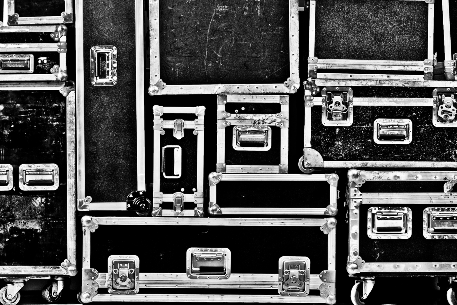 Numerous black road cases stack one on top of another in an organized, Tetris-like fashion.
